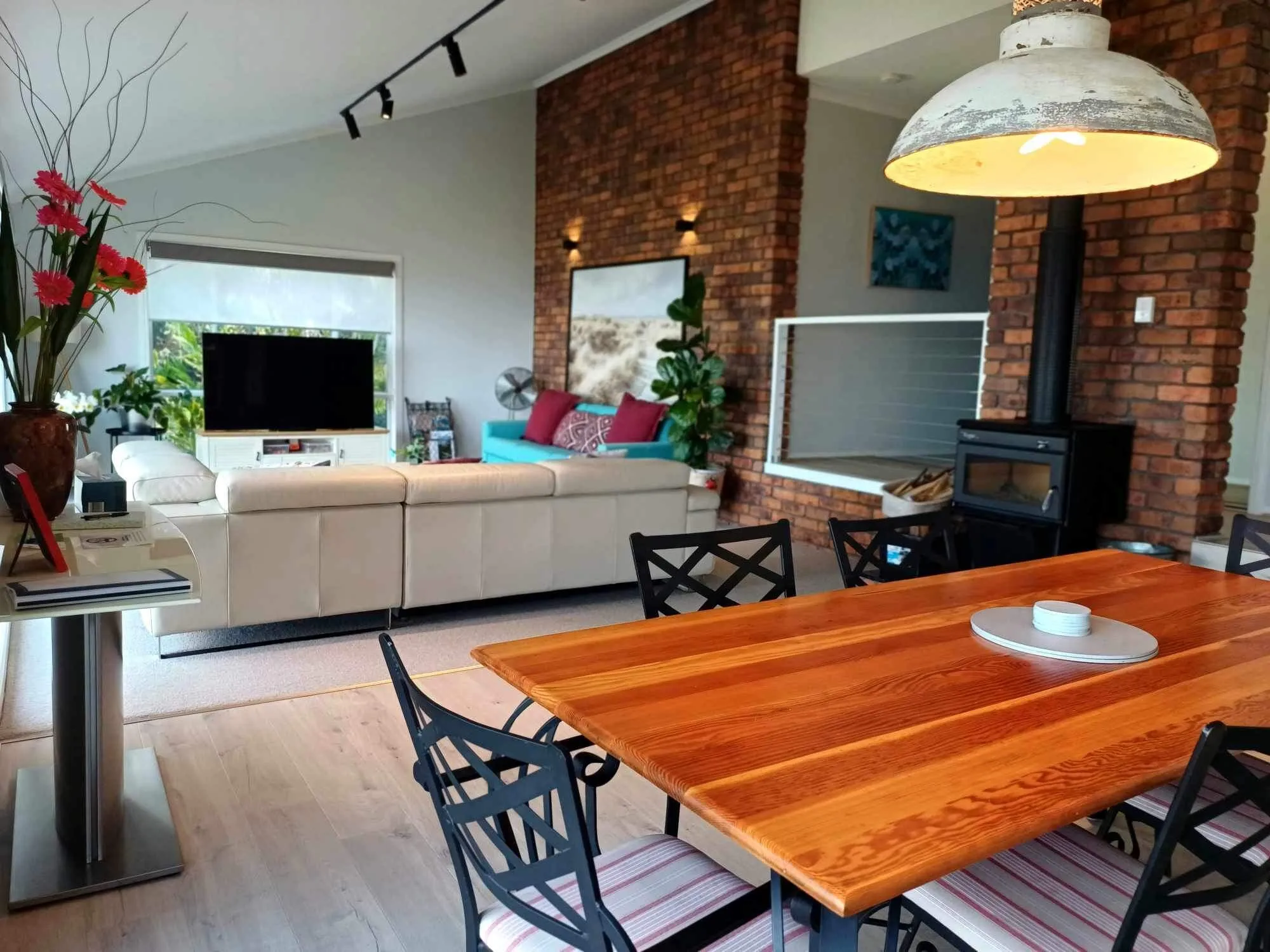Living area with brick fireplace wall, TV and dining table