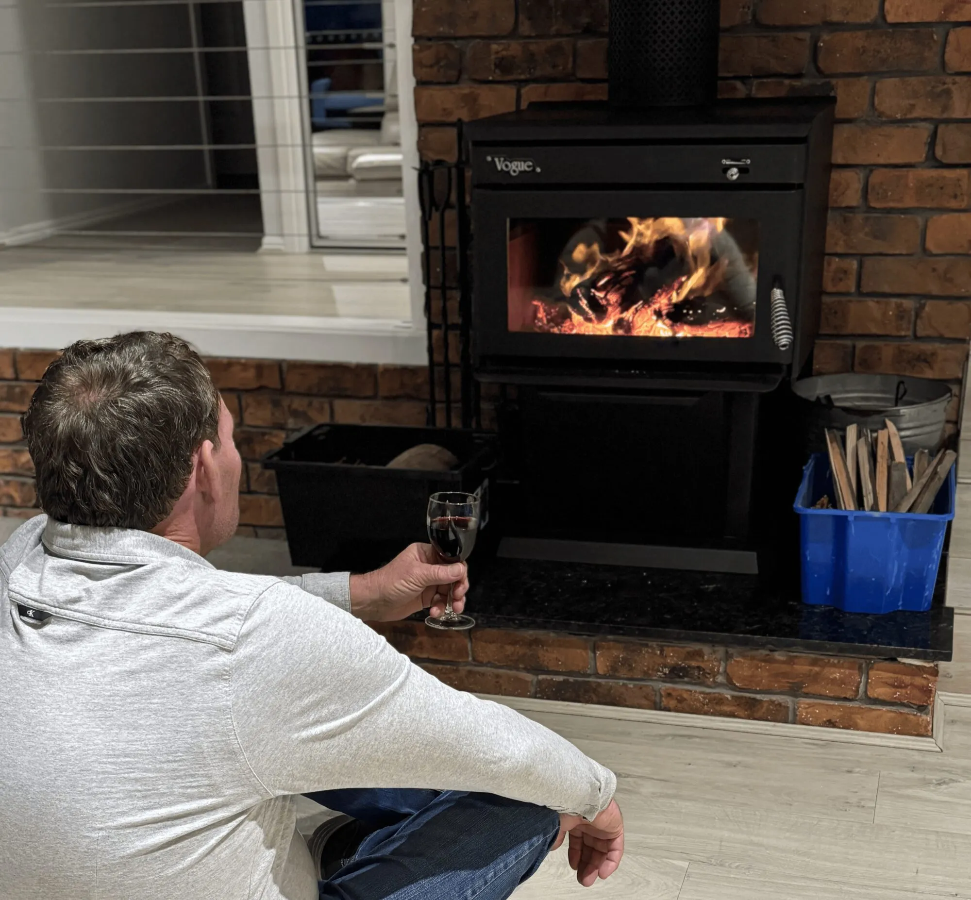 Guest enjoying a glass of wine by the wood fireplace