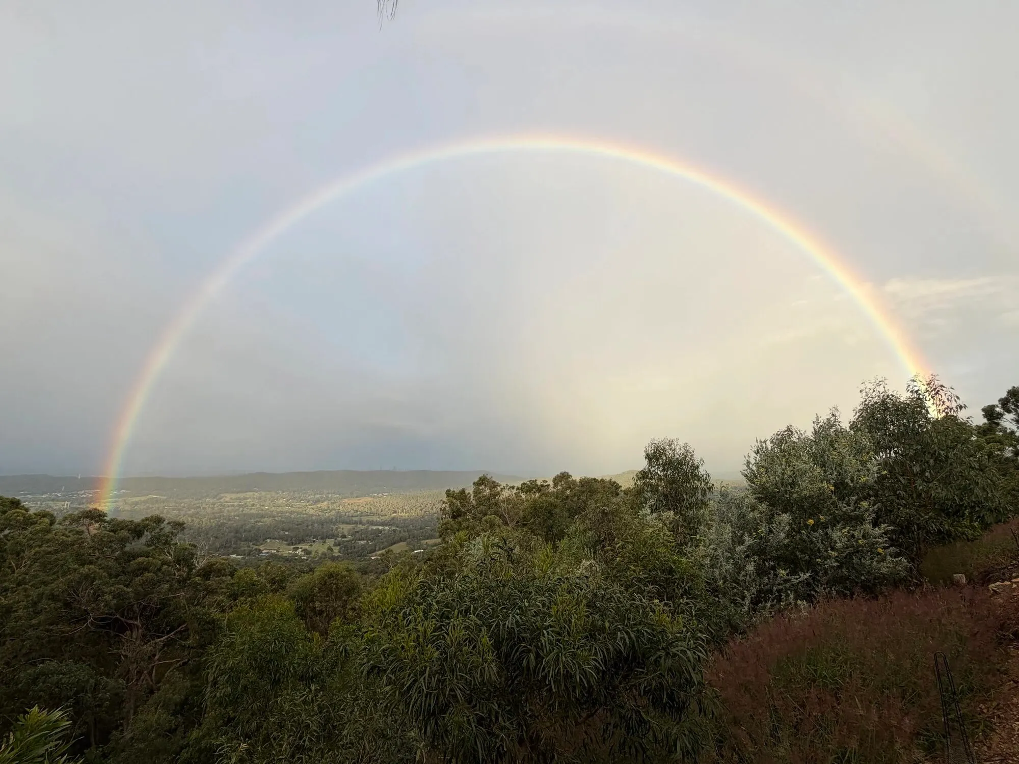 Rainbow arcing over the hinterland valley