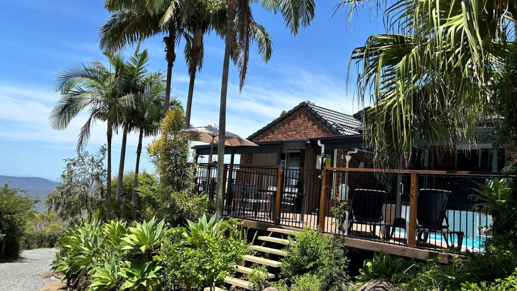 Palm-lined deck and steps beside the house