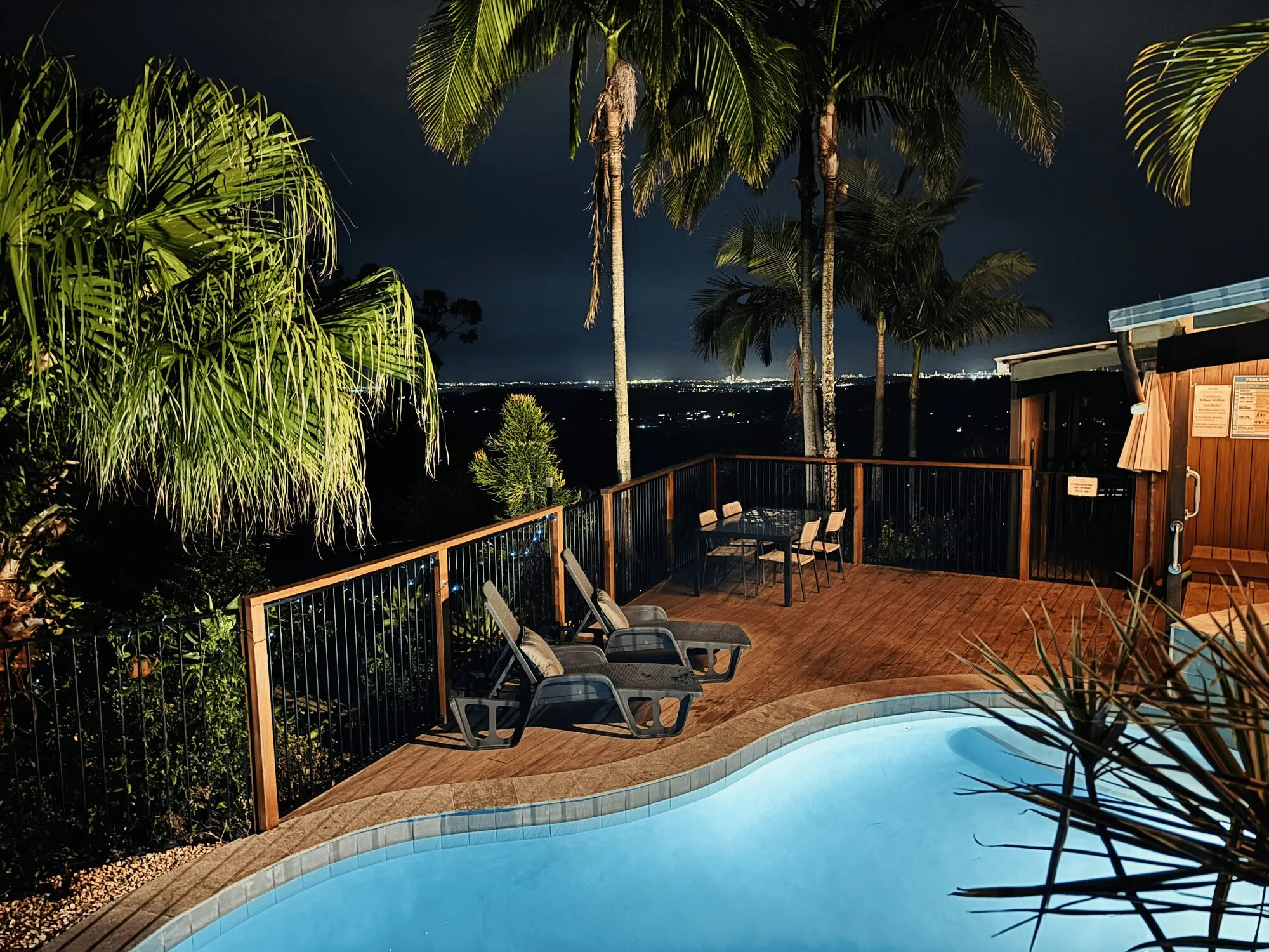 Pool deck at night with city lights beyond