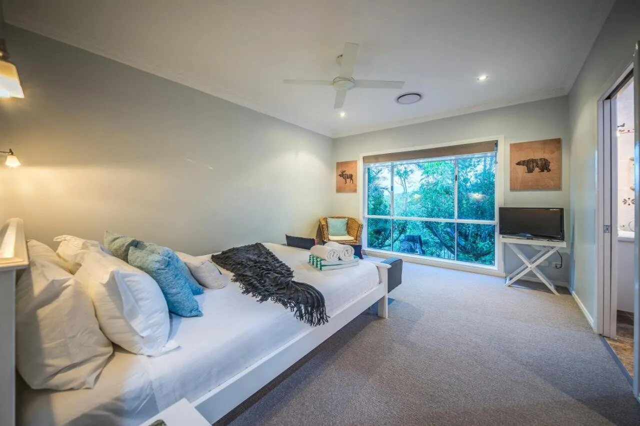 Queen bedroom with teal cushions and balcony view
