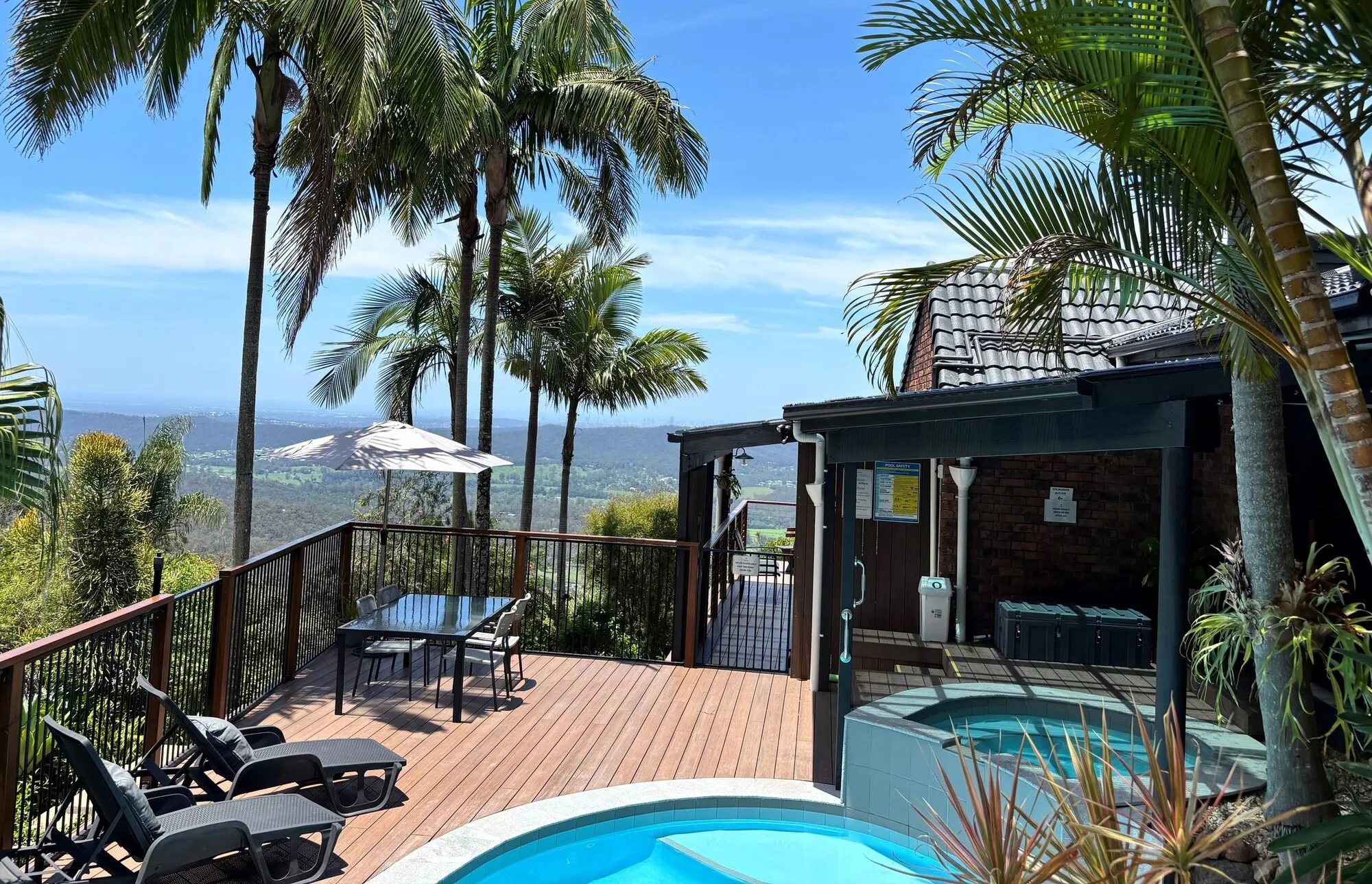 Pool, spa and palm-fringed deck with hinterland views