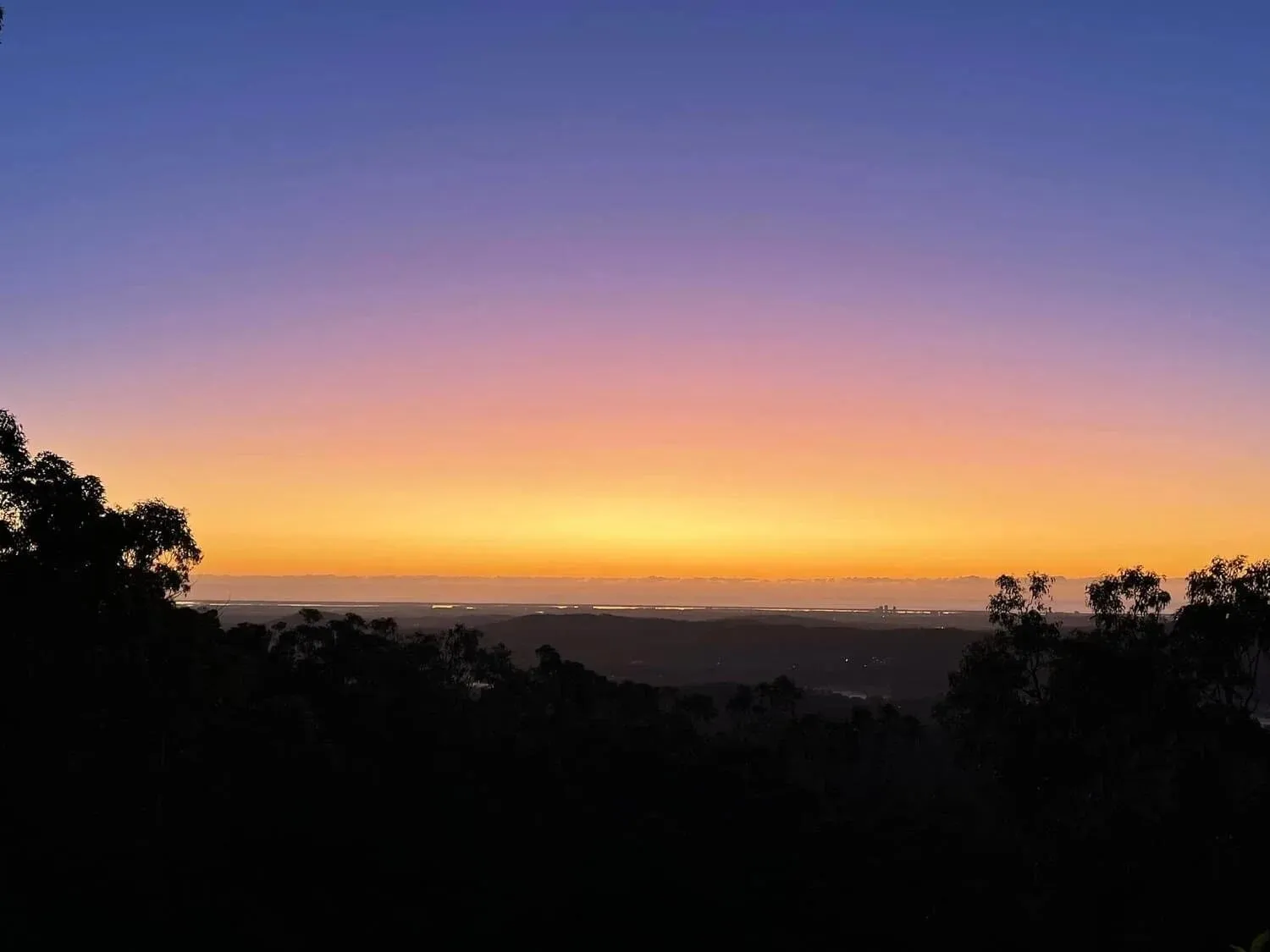 Pre-dawn purple and orange sky over the hills